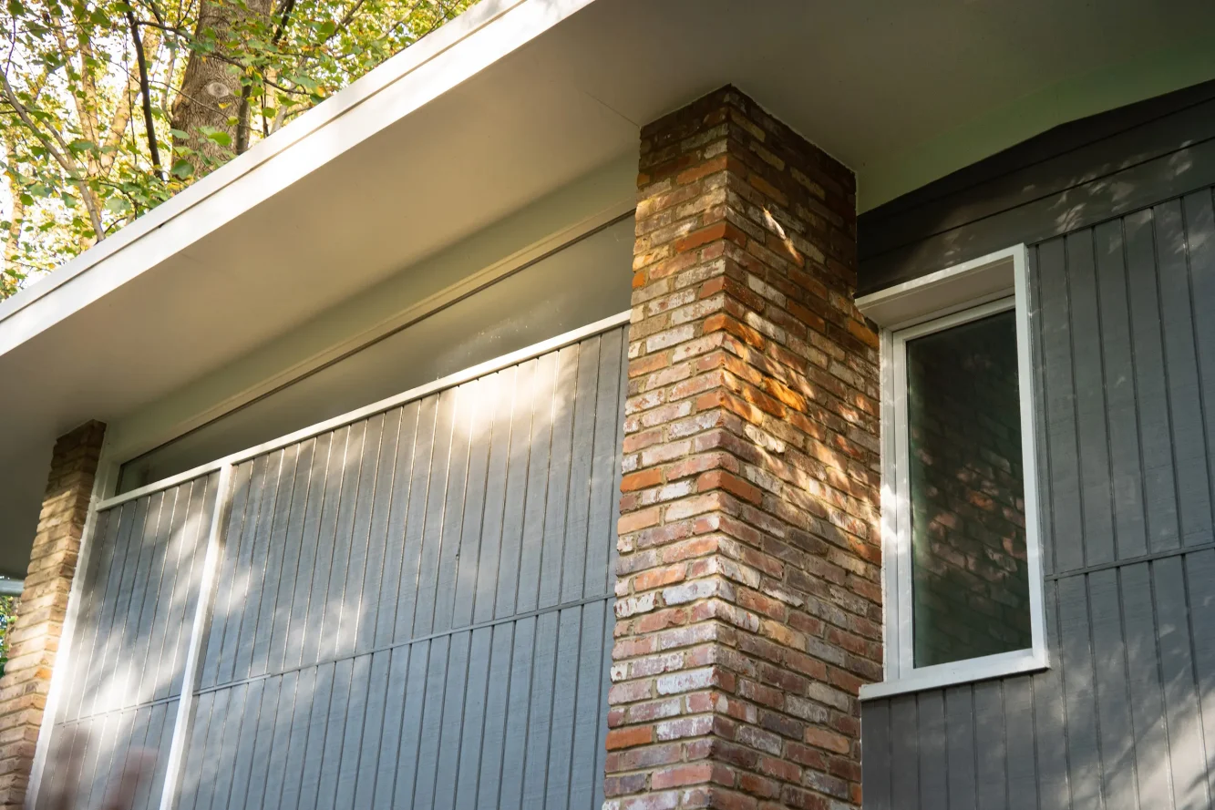 Exterior of home addition shows carefully matched brick and slot window detail
